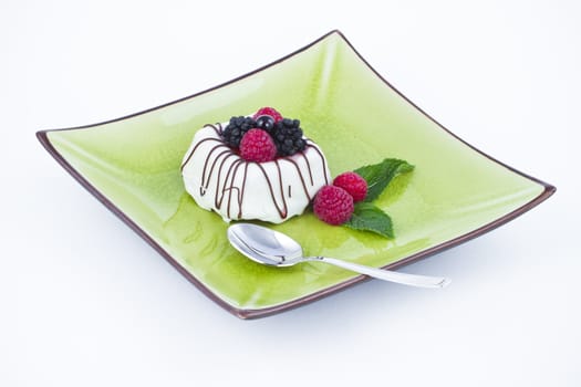 Black and white chocolate with blackberries on green plate