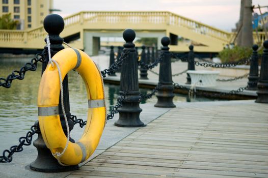 Yellow life buoy hanging on railing post