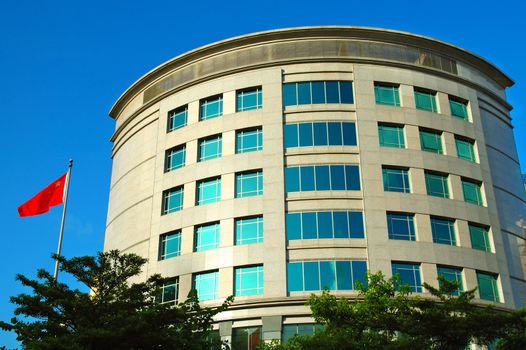 Modern office building with a flag over blue sky