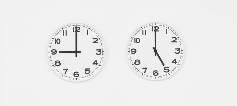 White clock with black hands showing nine to five o'clock