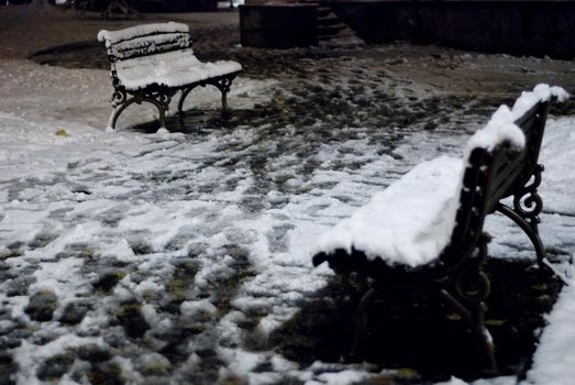 Two benches under the snow one is in front of another