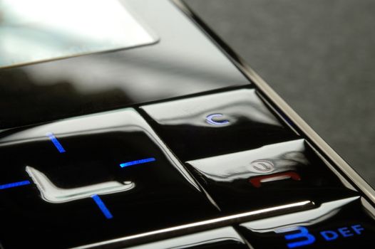 Close up shot of blue mobile keypad under dark environment