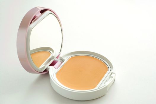 A vanity case of facepowder over white background