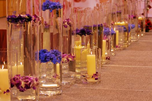 A row of different vases with flowers and candles