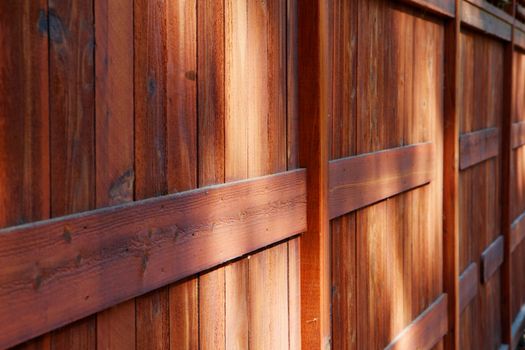 Red brown stained redwood fence in diminshing perspective