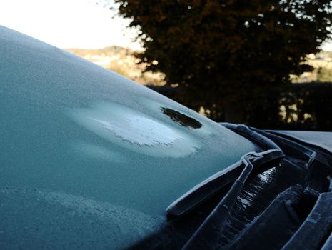 De-icing the windscreen on an icy Autumn morning