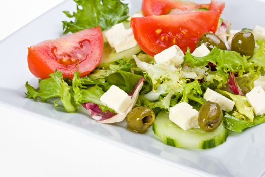 detail of a greek salad on a white plate