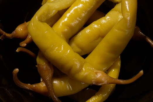 Hot green peppers, Spanish guindillas, on a black plate