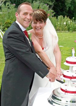 Mature, Happy, Bride and Groom Cutting the Cake at their Wedding Reception.