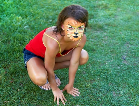 A young  girl painted up as a tiger