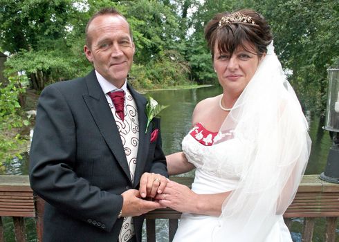 A Bride and Groom smiling at their reception after the wedding.