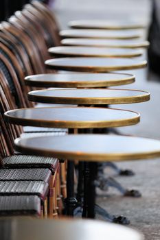 Several round tables in the typical cafe in Paris. Photo with tilt-shift effect