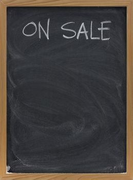 discount sale advertisement handwritten with white chalk on blackboard, copy space below