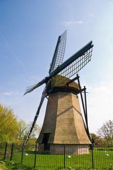 Dutch mill with fence on sunny april afternoon