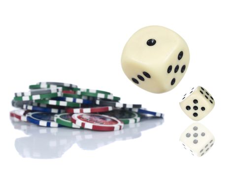 Two dices rolling beside some gambling chips. Isolated on white.