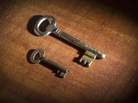 Two obsoletes keys over a wooden table.