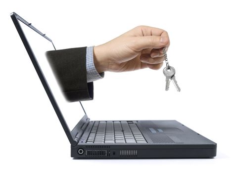 A hand holding a pair of keys comes from the laptop screen. Isolated over white background.