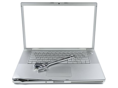 A spanner over a damaged laptop isolated over white background. White copy space on screen.