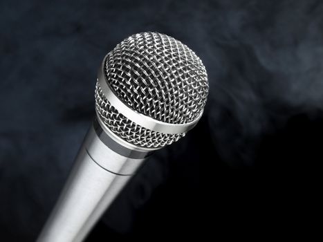 A dynamic microphone over a black and smoky background.