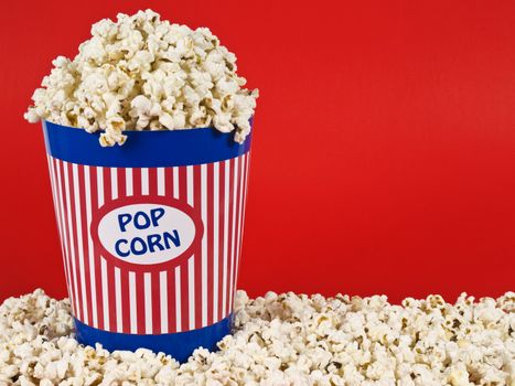 A popcorn bucket over a red background.