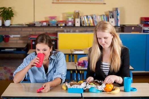 Two teenagers having a healthy school lunch in the classroom