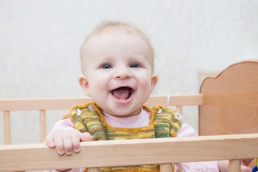 Smiling baby standing in his crib