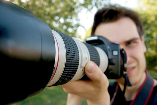 Portrait of a photographer taking pictures with a telephoto lens