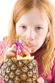 red head girl is drinking from a fresh pineapple isolated on white