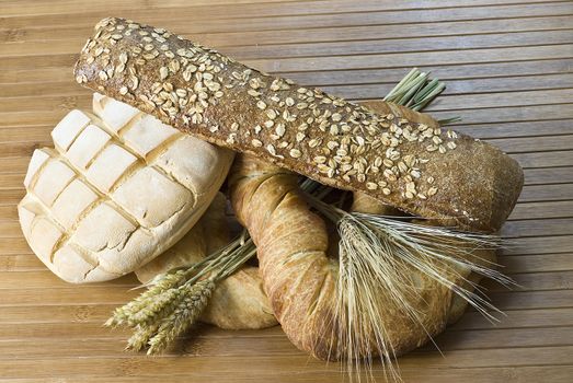 Some types of bread on a bamboo background.