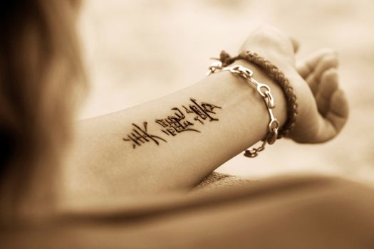 A woman's hands with a beautiful henna tattoo. Hieroglyph "Beautiful dream"