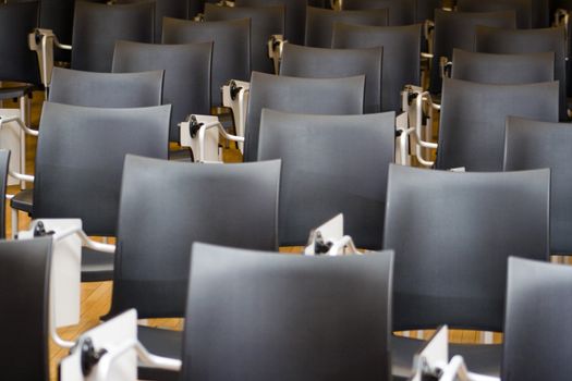 Empty black chairs in conference room. Shallow depth of field.