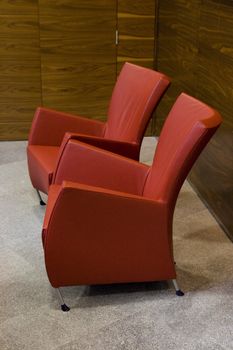 Empty modern red chairs in waiting room. Interior.