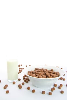 Chocolate balls with milk for breakfast in ceramic bowl. Isolated on white.