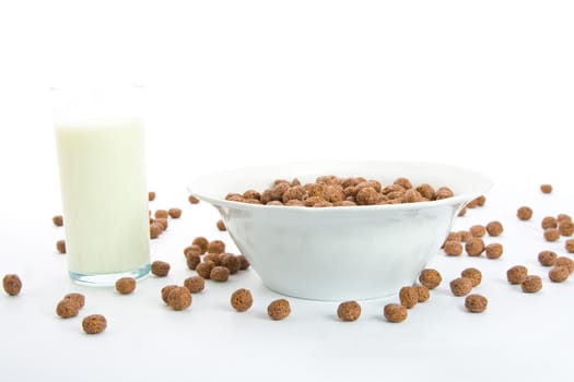 Chocolate balls with milk for breakfast in ceramic bowl. Isolated on white.