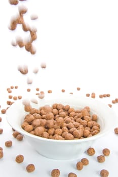 Chocolate balls falling in ceramic bowl-blur representing motion. Isolated on white.