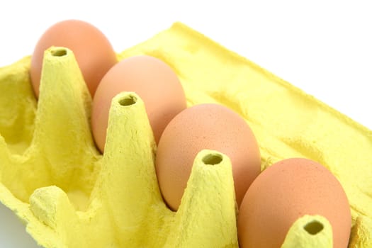 Carton of few eggs in a cardboard box. Isolated on white background.