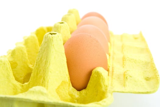 Carton of few eggs in a cardboard box. Isolated on white background.