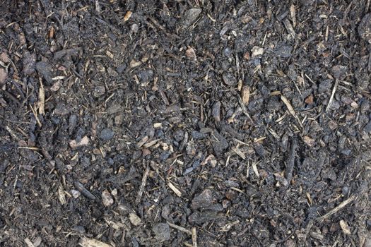 moist garden potting compost background with small wood chips, bark and sticks