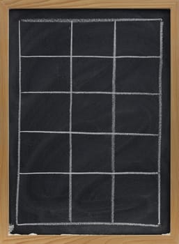 blank table sketched with white chalk on blackboard with eraser smudges