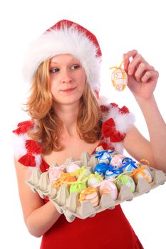 Miss Santa is holding a package of colourful easter eggs, one egg in her hand - sceptical surprised look