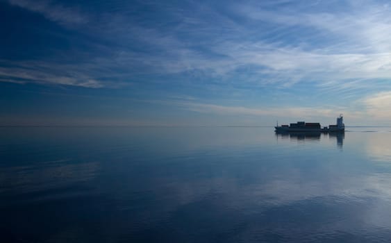 Ship filmed at sunset in Baltic sea going between sea and blue sky