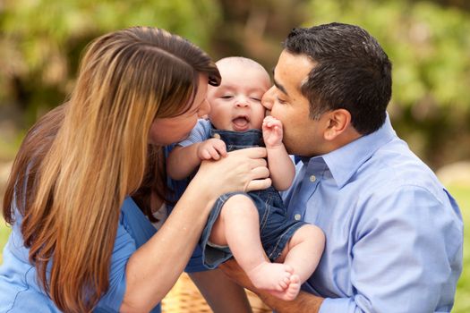 Happy Mixed Race Parents Playing with Their Giggling Son.