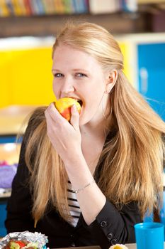 Blond schoolgirl eating an apple