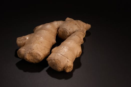 Raw ginger root taken on black background