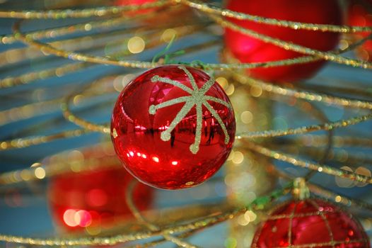 Some christmas balls decorated on a golden frame made tree