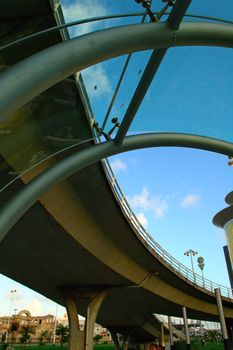 An abstract view of curve form by overbridge and glass shield of escalator