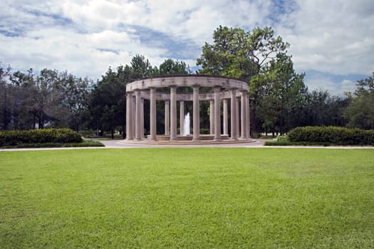 A classical monument with a single fountain behind a great lawn