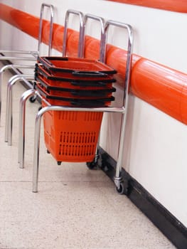 A photograph of red shopping baskets in a store.