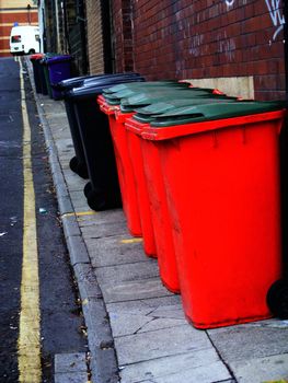 A photograph of street side red bins