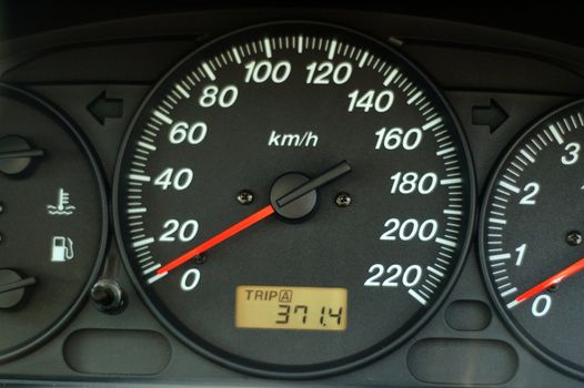 A close up of car dashboard with speed over black background